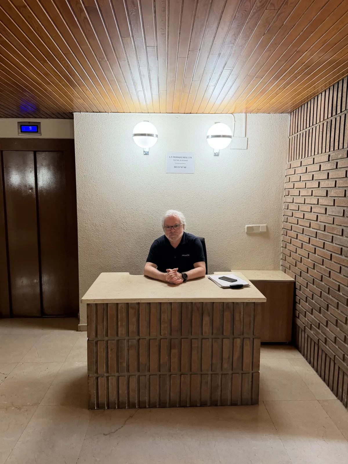 Conserje en la mesa de portería de un vestíbulo clásico